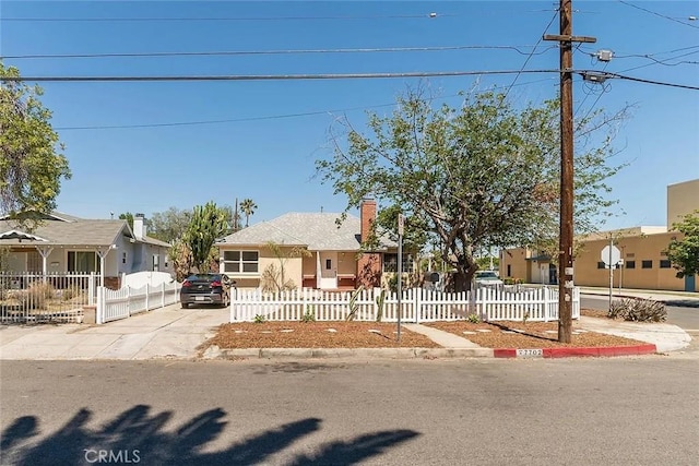 view of front of property with a fenced front yard, a chimney, and a residential view