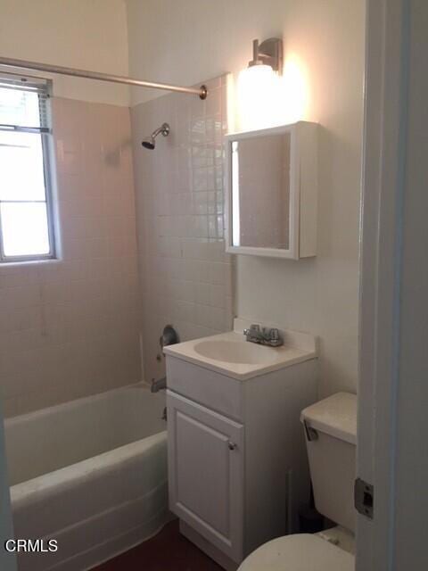 bathroom featuring toilet, shower / bathing tub combination, and vanity