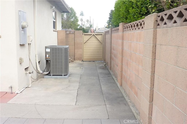 view of property exterior with cooling unit, a gate, fence, and stucco siding