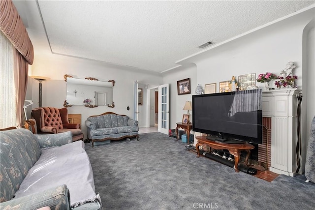 carpeted living area featuring visible vents, a textured ceiling, crown molding, and french doors