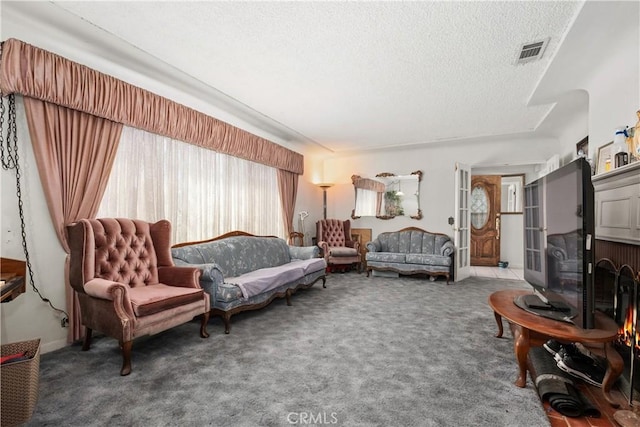 carpeted living room featuring visible vents and a textured ceiling