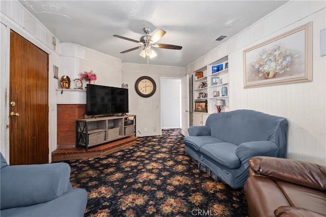 carpeted living room featuring built in features, visible vents, and ceiling fan