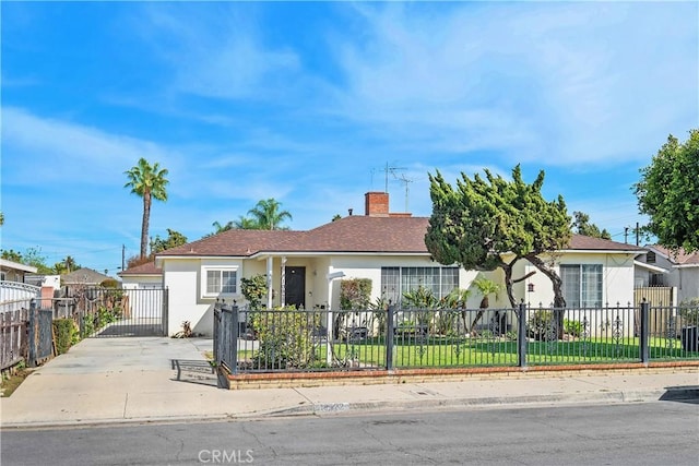 view of front facade featuring a fenced front yard, a chimney, and stucco siding