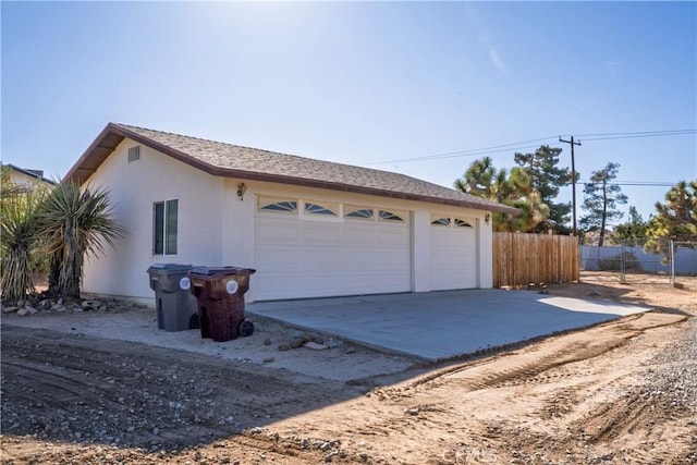 exterior space featuring concrete driveway and fence