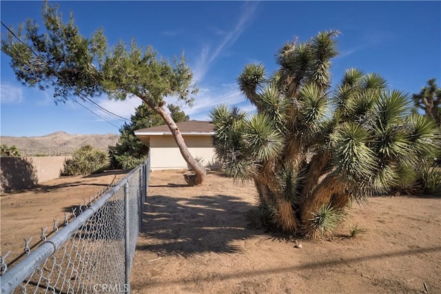 view of yard featuring fence and a mountain view