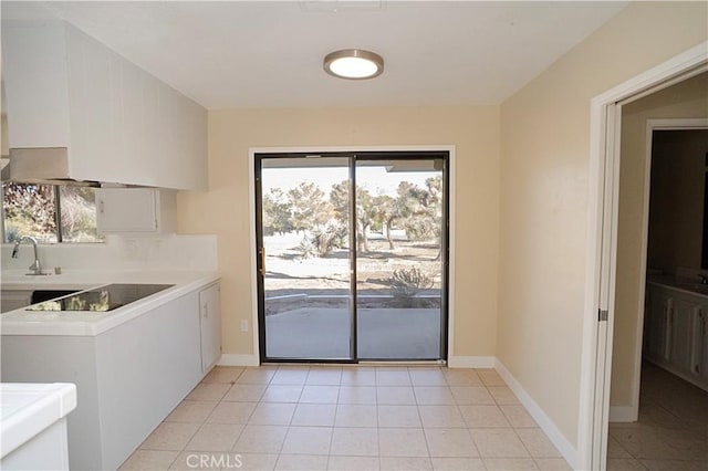 interior space with light countertops, a sink, white cabinetry, and a healthy amount of sunlight