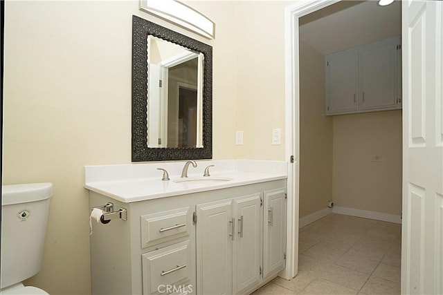 bathroom featuring toilet, tile patterned flooring, baseboards, and vanity