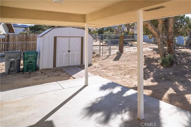 view of patio / terrace featuring an outbuilding, a storage unit, and fence