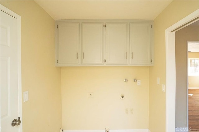 washroom with gas dryer hookup, baseboards, and wood finished floors