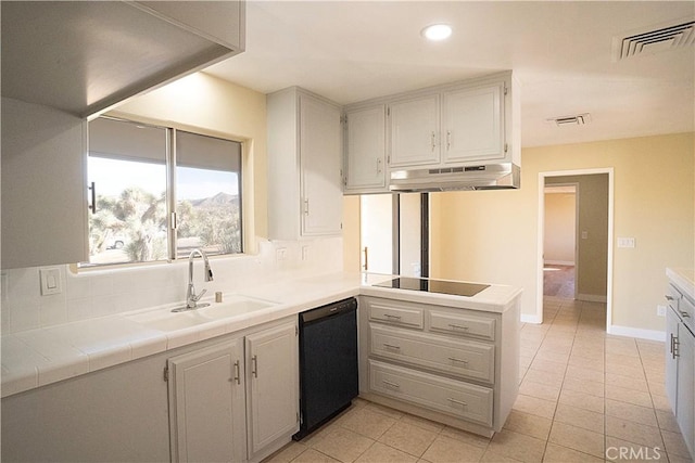 kitchen with light tile patterned floors, under cabinet range hood, a sink, visible vents, and black appliances