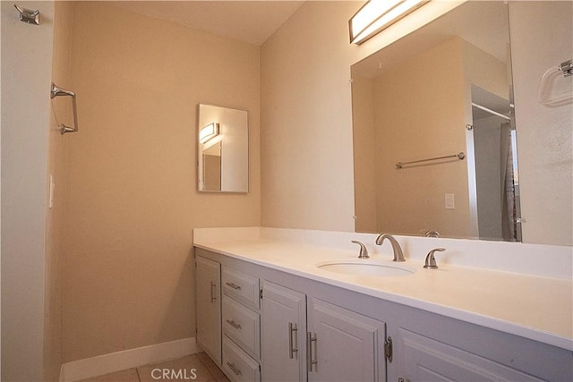 bathroom featuring a shower, tile patterned flooring, vanity, and baseboards