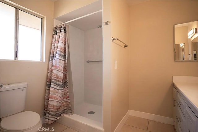 bathroom with curtained shower, tile patterned flooring, toilet, vanity, and baseboards