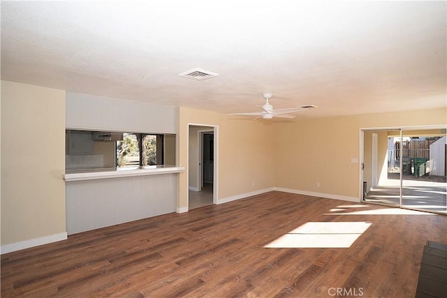 spare room with baseboards, wood finished floors, visible vents, and a ceiling fan