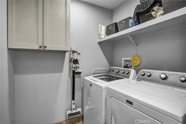 laundry room with independent washer and dryer and cabinet space