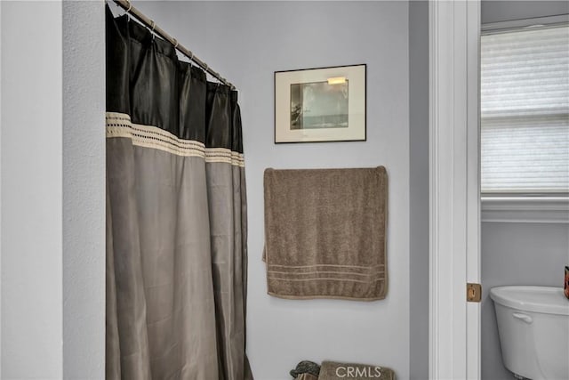 bathroom with curtained shower and toilet