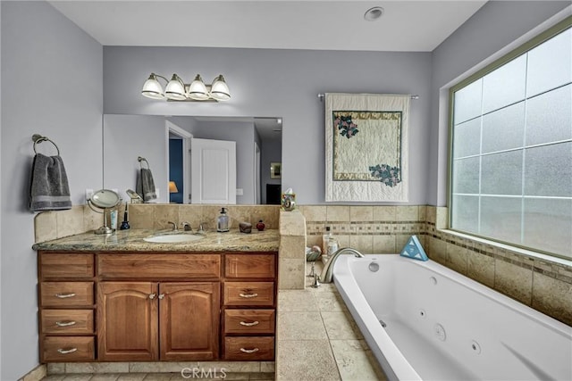 full bathroom featuring a jetted tub and vanity