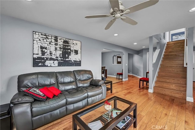 living room with baseboards, a ceiling fan, stairs, light wood-style floors, and recessed lighting