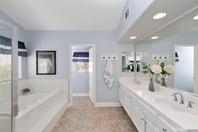 full bath with visible vents, a sink, baseboards, and a bath