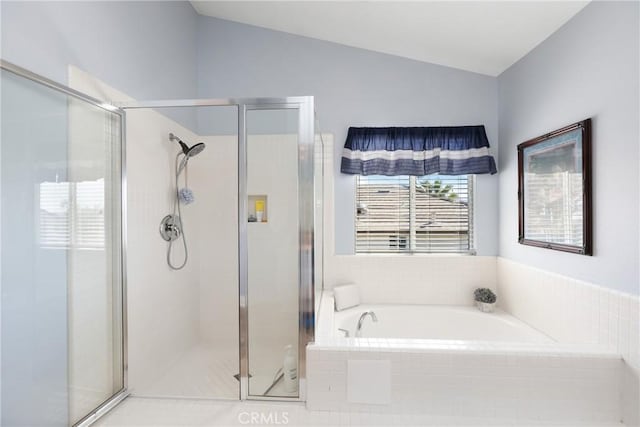 bathroom with vaulted ceiling, a shower stall, and a bath