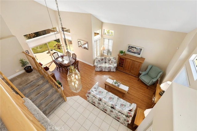 living room with high vaulted ceiling, stairway, wood finished floors, and baseboards