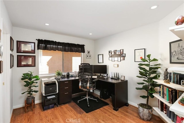 office space featuring baseboards, light wood-style flooring, and recessed lighting