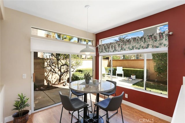 dining area with baseboards and wood finished floors