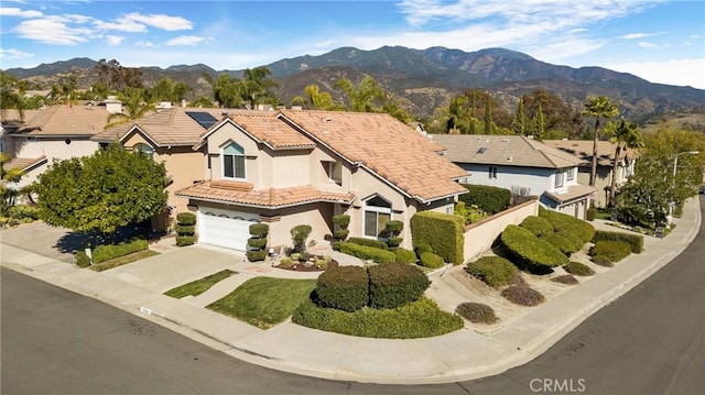 view of front of house featuring roof mounted solar panels, driveway, a tiled roof, and a mountain view