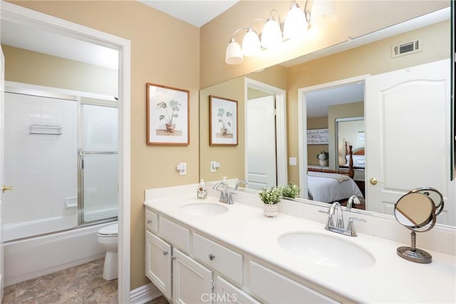 ensuite bathroom with toilet, connected bathroom, visible vents, and a sink