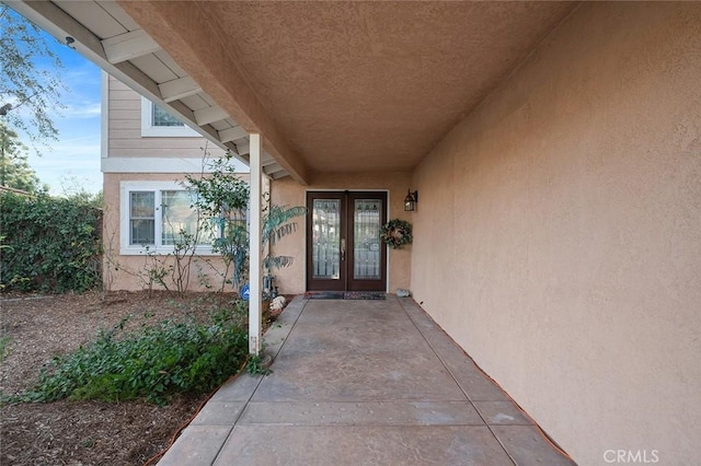 entrance to property featuring french doors and stucco siding