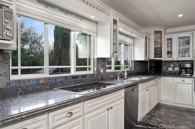 kitchen with black electric stovetop, decorative backsplash, white cabinets, a sink, and dishwasher