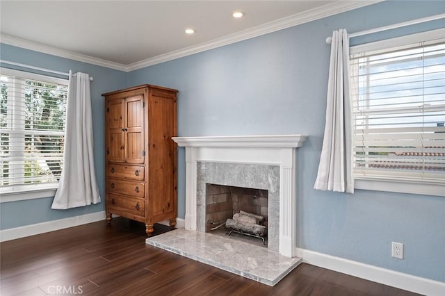 unfurnished living room featuring dark wood-style flooring, a healthy amount of sunlight, crown molding, and baseboards