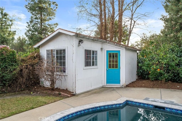 view of outbuilding featuring an outdoor pool and an outdoor structure