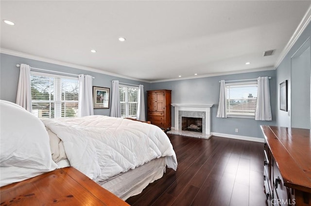 bedroom featuring a fireplace, visible vents, baseboards, dark wood finished floors, and crown molding