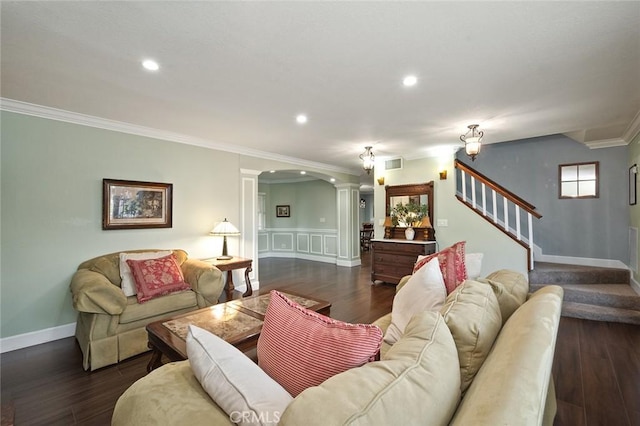 living room featuring stairs, visible vents, dark wood-style floors, and decorative columns