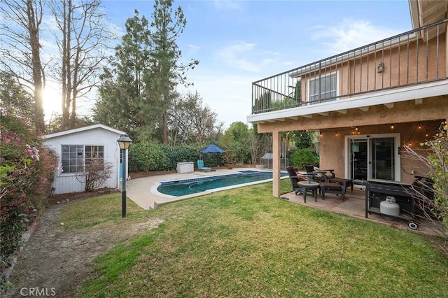 view of yard featuring an outbuilding, a patio area, a balcony, and an outdoor pool