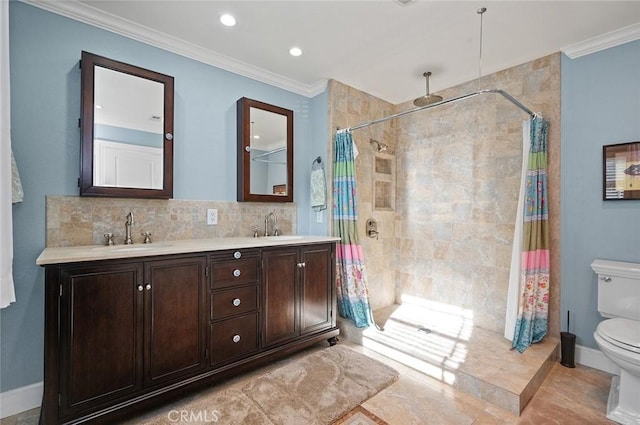 bathroom featuring crown molding, a sink, a tile shower, and toilet