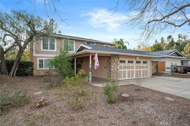 view of front of home with a garage, stone siding, and driveway