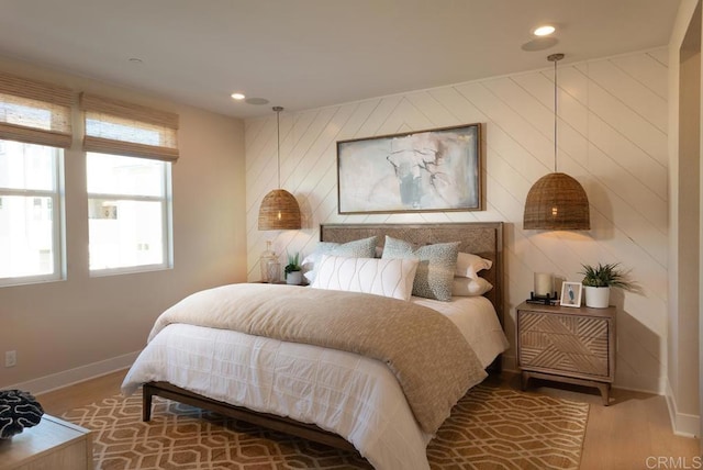 bedroom featuring baseboards, wood finished floors, and recessed lighting