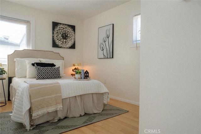 bedroom with baseboards and wood finished floors