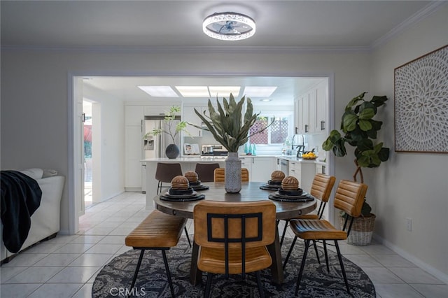 dining area featuring light tile patterned floors, baseboards, and ornamental molding