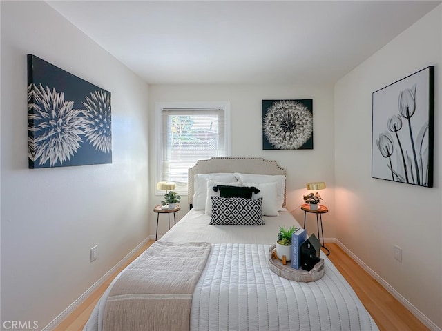 bedroom with baseboards and wood finished floors