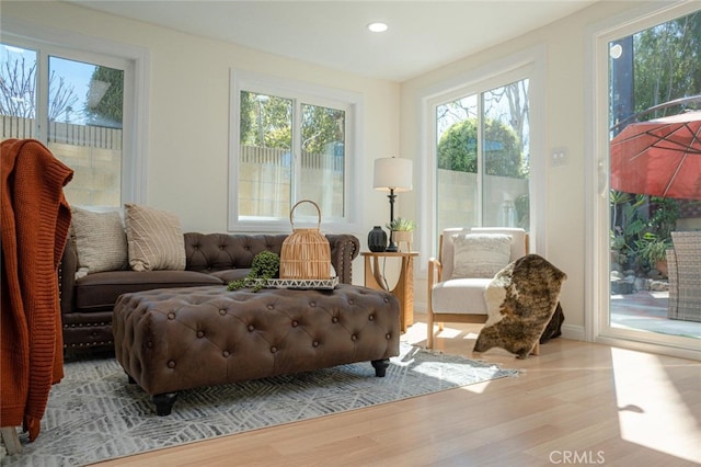 sitting room with recessed lighting, a healthy amount of sunlight, and wood finished floors