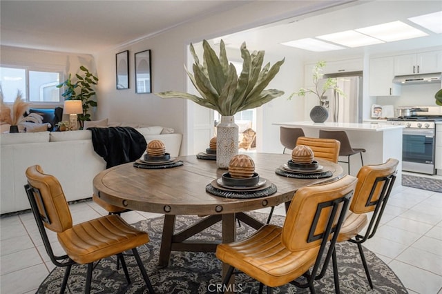 dining space featuring light tile patterned floors and ornamental molding