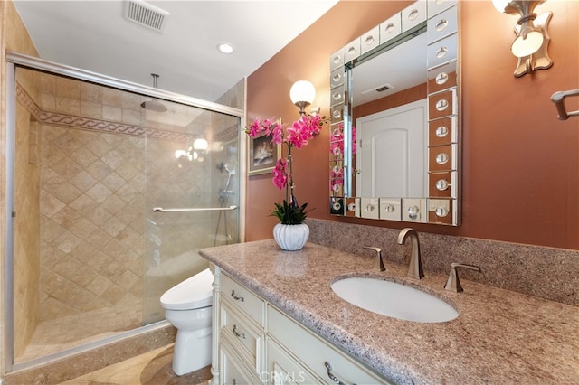 full bathroom featuring a stall shower, visible vents, vanity, and toilet