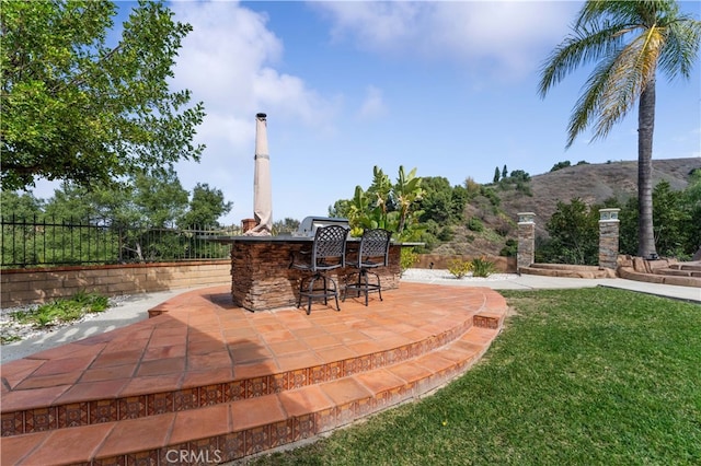 view of patio with fence and outdoor dry bar