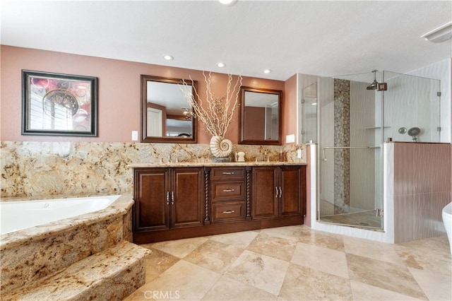 full bathroom featuring double vanity, a shower stall, a sink, and a bath