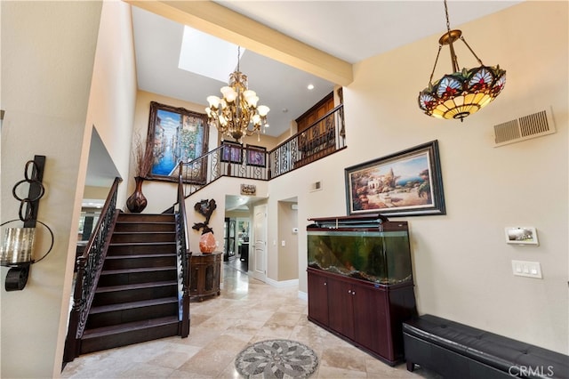 entryway with baseboards, visible vents, stairway, a high ceiling, and a notable chandelier