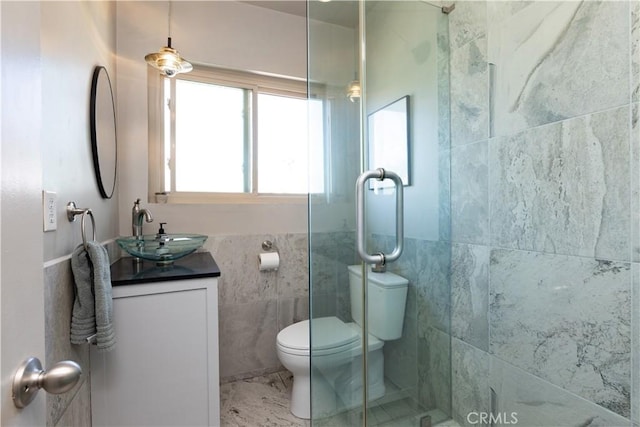 full bathroom with toilet, an enclosed shower, vanity, and tile walls