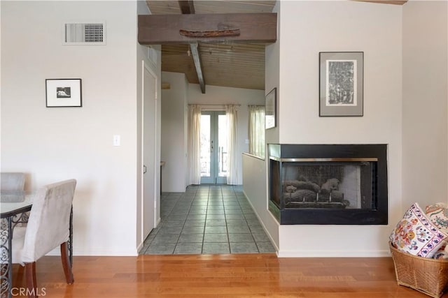 hallway with french doors, visible vents, vaulted ceiling with beams, and wood finished floors