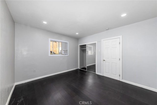 unfurnished bedroom with a closet, recessed lighting, dark wood-style flooring, and baseboards